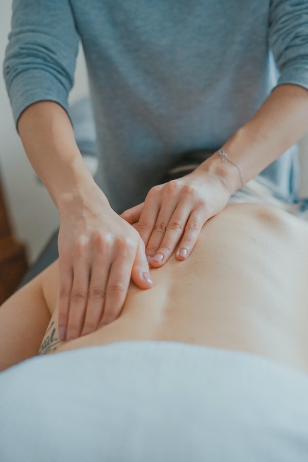 Physical therapist massaging client's lower back