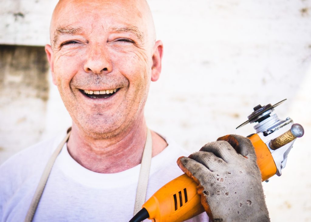 Handyman smiling while holding a power tool