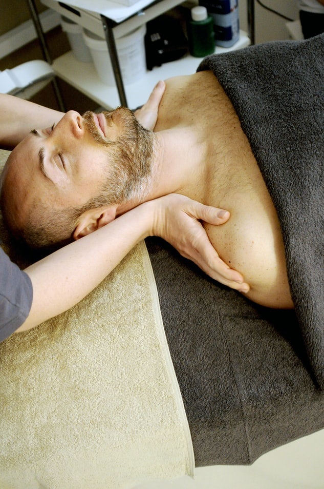 Massage therapist massaging client's shoulders