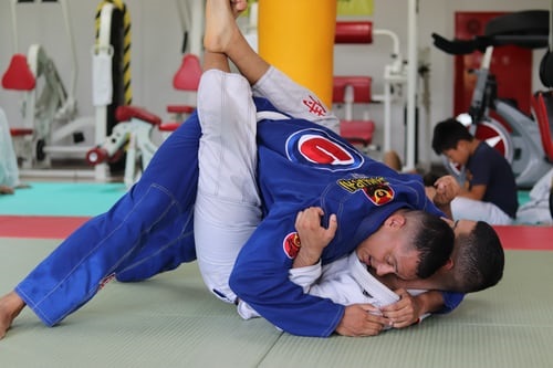 Judo instructor demonstrating a grappling move on a partner