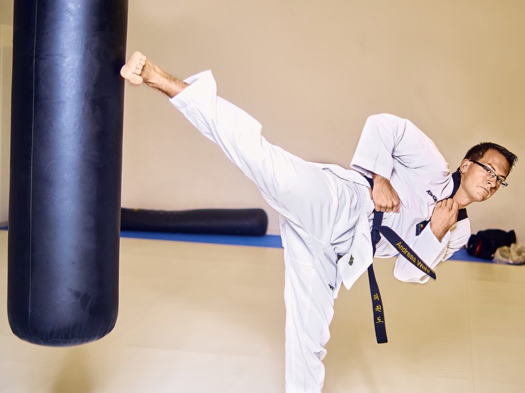 Taekwondo instructor kicking a punching bag