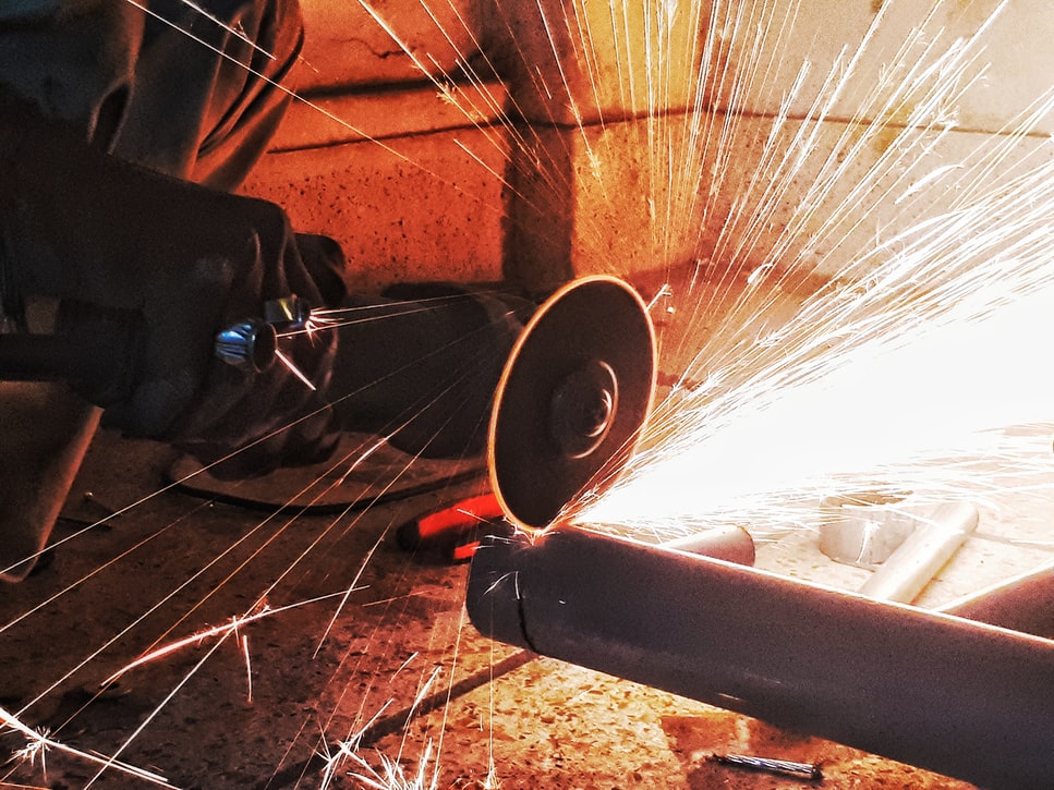 Plumber using a power saw to cut a pipe