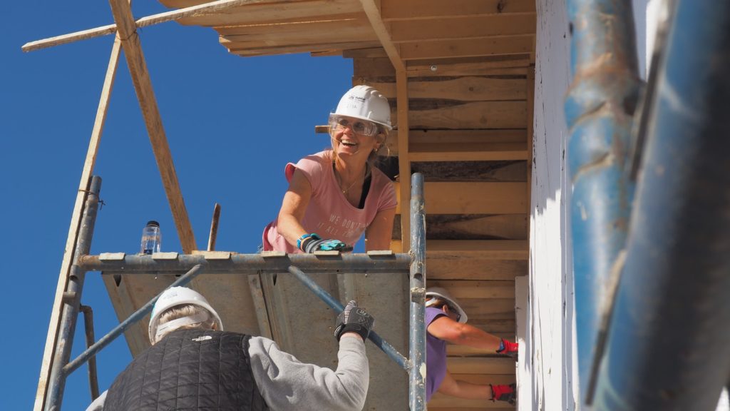 Carpenters working together to build walls and a roof