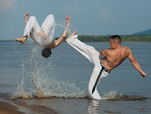 Capoeira fighters training in the water