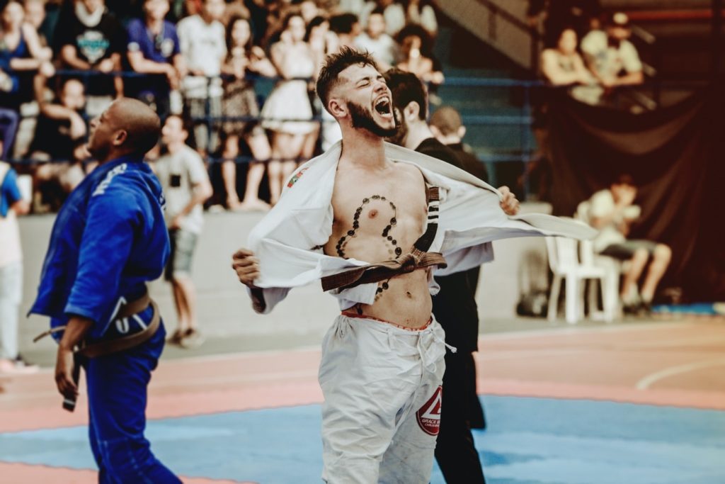 Kung Fu fighter ripping shirt open in celebration